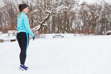 Standing girl wearing winter sportswear, trees background