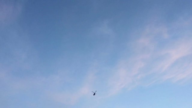 Helicopter flying against the blue sky.