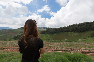 Fototapeta na wymiar Asian girl standing in front of rice terrace in Thailand and thinking something