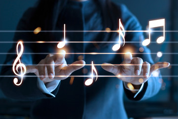 Obraz premium Kobiet ręki bawić się muzyk notatki na ciemnym tle, muzyczny pojęcie