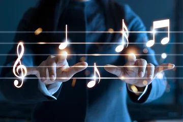  Woman hands playing music notes on dark background, music concept © ipopba