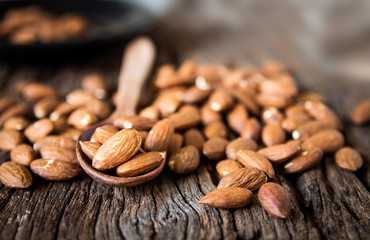 close up Peeled almonds nut in spoon on wooden  background