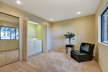 Black leather armchair in the corner of laundry room