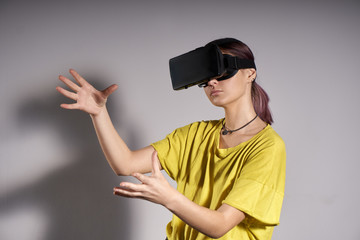 Woman in VR glasses looking up and touch objects