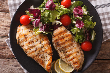 Grilled chicken breast with mixed salad close-up. horizontal top view