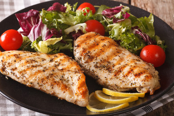 Grilled chicken breast with salad of chicory, tomatoes, cabbage and lettuce close-up. horizontal