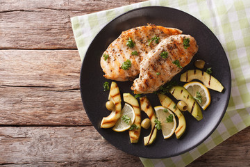 Grilled chicken breast with avocado, lemon and olive close-up. horizontal top view © FomaA