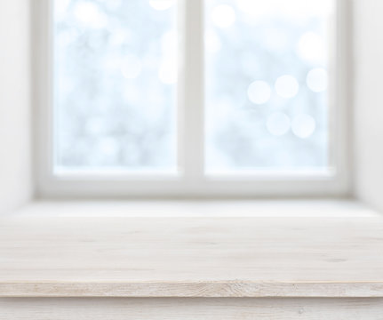 Wooden texture table surface over abstract frosty winter window background