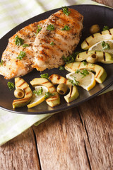 Healthy food: Grilled chicken breast with avocado, lemon and olive close-up. vertical