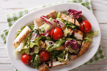 Sliced grilled chicken with mixed salad and tomatoes close-up. Horizontal top view