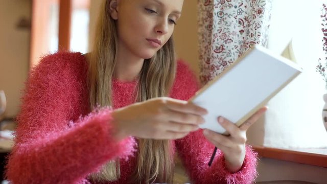 Girl stops reading book because of painful headache
