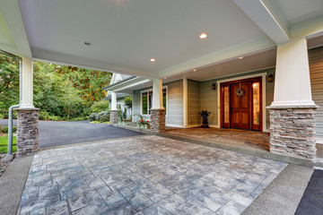 View of driveway with an all weather covered entry