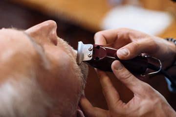 Top view of senior man getting his mustache trimmed