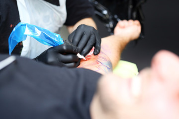 Kolorowy tusz do tatuażu. Tatuażysta tatuuje kolorowy tatuaż