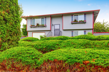 Two story house with gray exterior paint and red trim