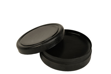 black shoe polish lid ajar on a white background