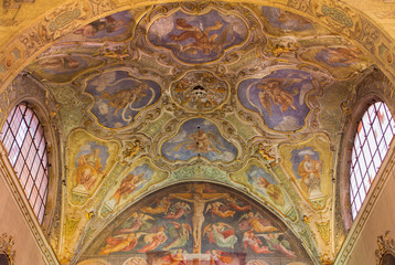 Fototapeta na wymiar BRESCIA, ITALY - MAY 22, 2016: The ceiling baroque frescoes of side chapel and gothic-renaisscane fresco of Crucifixion by Andrea Bembo (1475) in church Chiesa di Santa Agata.