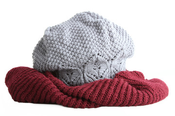 Knitted maroon hat and  grey scarf, isolated on white background
