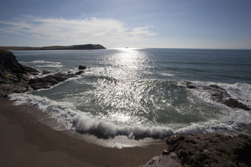 Waves roll in to a beach at Polzeath, Cornwall, UK