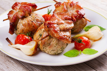 Meat rolls on scewers with cherry tomatoes and garlic