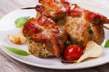 Meat rolls on scewers with cherry tomatoes and garlic
