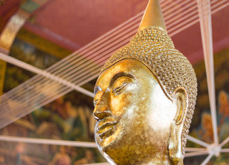 Closeup of the face and hands of buddha's image covering with go