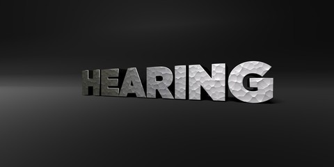 HEARING - hammered metal finish text on black studio - 3D rendered royalty free stock photo. This image can be used for an online website banner ad or a print postcard.