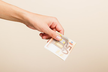 Woman's hand with money on a light background