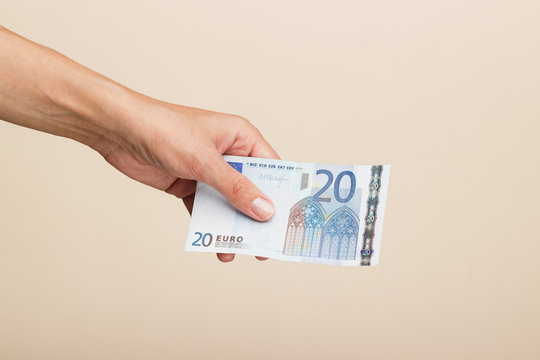 Woman's hand with money on a light background