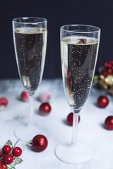 Christmas illuminations with champagne glass. Glasses of champagne with bubbles on snow. Black background