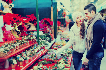 Obraz premium girl with boy choosing Christmas flower