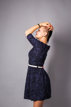 Fashionable beautiful young woman posing in studio. Girl with black short haircut.