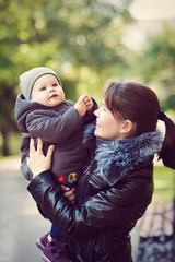 Fototapeta premium Mother and daughter walking in the Park, cool weather.