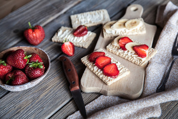 Fruity toast on wooden background. Strawberries, bread, butter and cheese.Vintage style