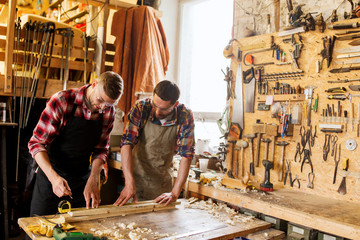 carpenters with ruler and wood plank at workshop