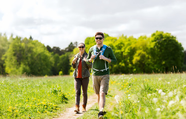 happy couple with backpacks hiking outdoors