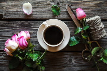 Fresh roses with diary and cup of coffee on wooden table, top view. flowers, hot drink