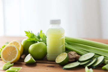 close up of bottle with green juice and vegetables