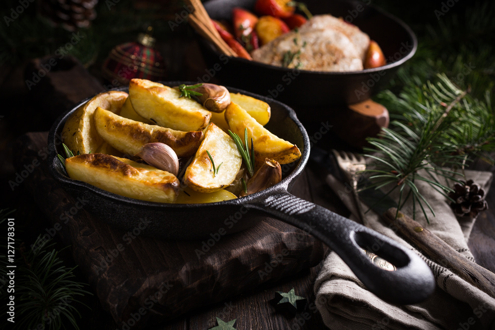 Wall mural delicious christmas themed dinner table with baked potatoes and garlic. holiday concept.