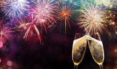 Two glasses of champagne over fireworks background