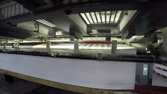 zooming in on a sheetfed offset printing mashine at work