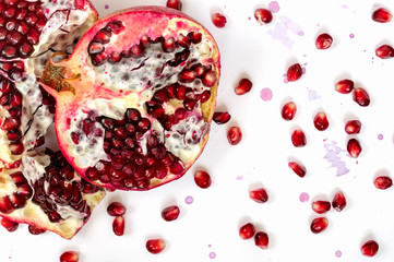 Pomegranate fruit and seeds on white background