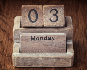 Grunge calendar showing Monday the third on wood background