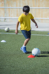 Niño en un entrenamiento de fútbol 7, deportes de equipo para actividades extraescolares