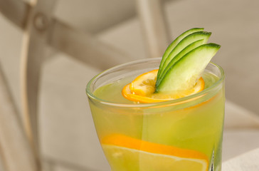 glass transparent glass with juice and lemon on the table against the background of the chair and the sofa close-up