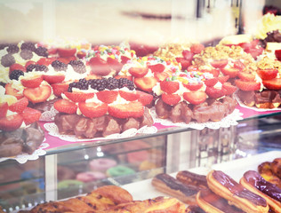Sweet baked goods behind a shop window, bakery scene with delicious sweets.