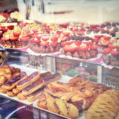 Sweet baked goods behind a shop window, bakery scene with delicious sweets.