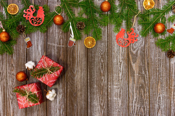 Christmas background with decorations and gift boxes on wooden board