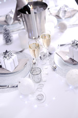 bright white and silver new year eve or christmas table in a luxury restaurant with champagne