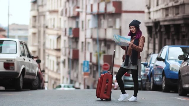City girl tourist with a luggage studying a map
